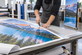 Technician finishing a professional large-format display graphic